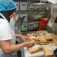 A young person filling food orders for Enable Works